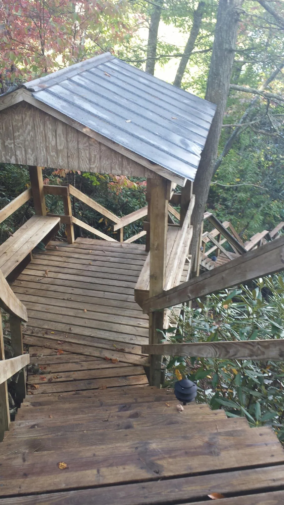 Metal roofed shelter over wooden steps on a wooded walkway — Skylight Repair & Installation work by our crew in Steep Falls